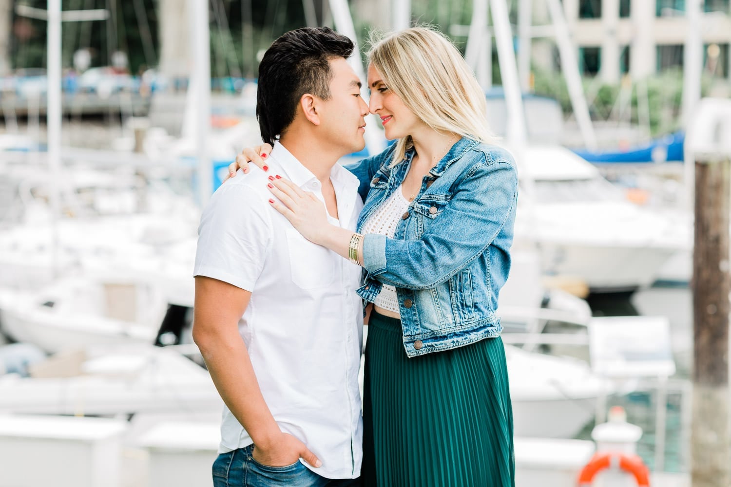 cute engaged couple posing on Granville Island for engagement photographer in Vancouver