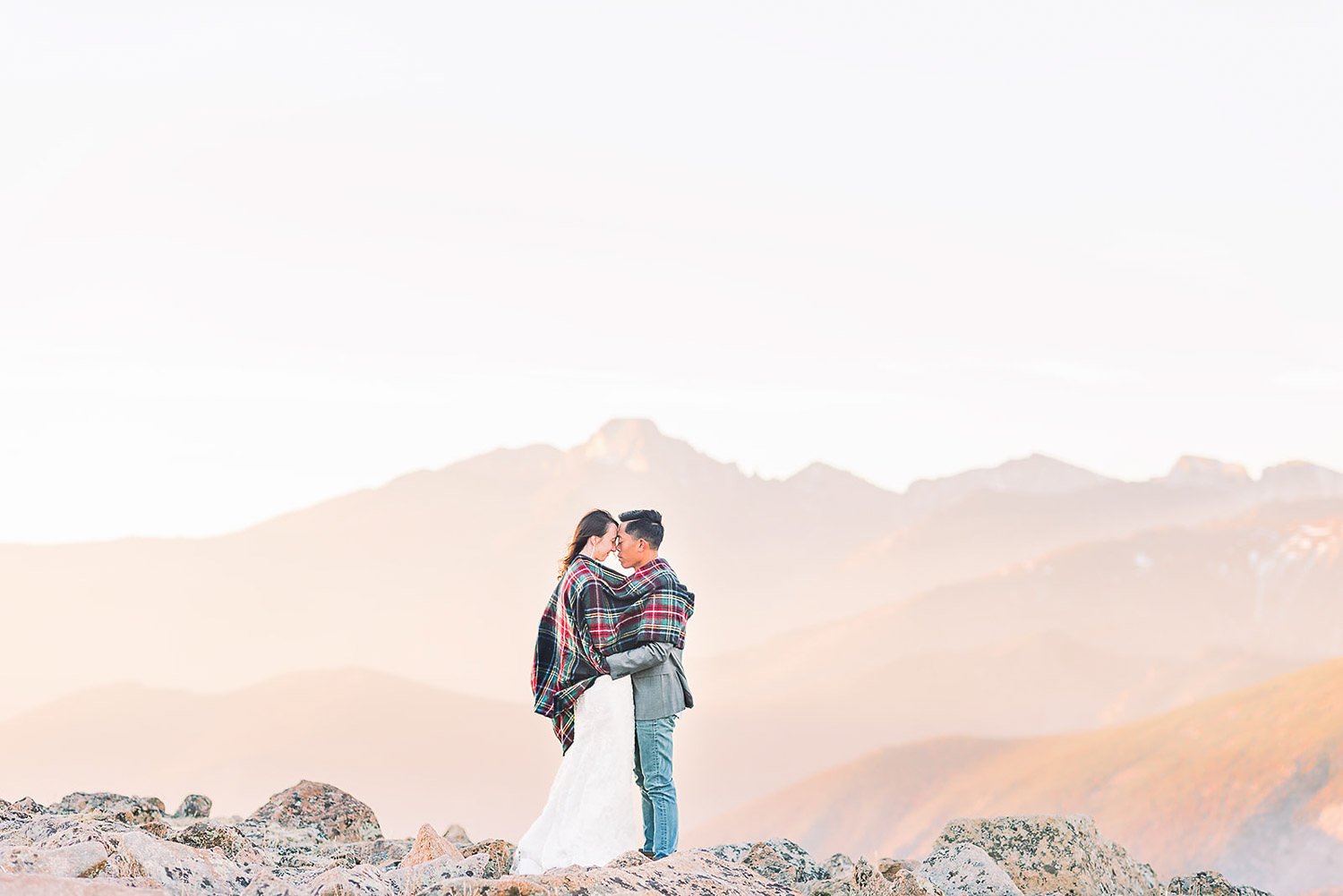 bride and groom holding each other with the blanket on the shoulders with the best photography location at the background